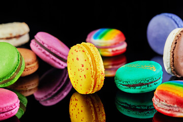 Fototapeta na wymiar Assorted colorful macarons folded and arranged on a black surface with reflection