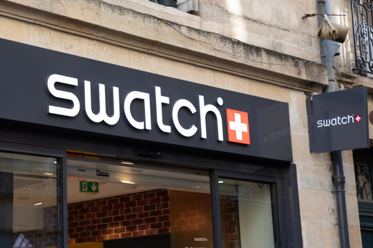 Swatch logo brand and text sign on wall entrance facade store swiss signage chain watch