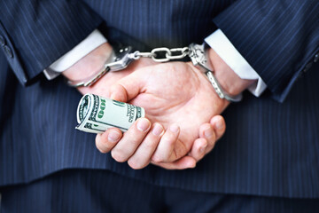 Business person, hands and money with handcuffs for bribe, secret or corruption in financial crime....