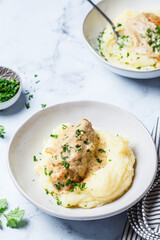 Chicken breast in creamy sauce with mashed potatoes.