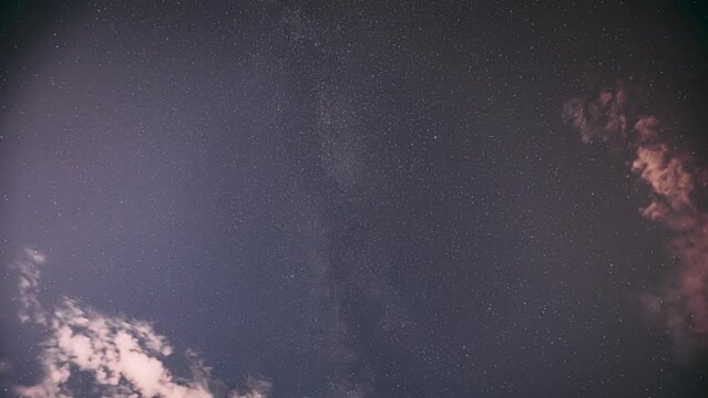 Cloudy Night Starry Sky With Glowing Stars. Bright Glow Of Sky Stars And Milky Way Galaxy. 4K. Natural Background Backdrop. time lapse, timelapse, time-lapse,