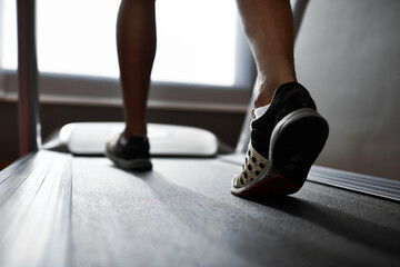 Sports, feet and person running on treadmill in gym for health, wellness and body training. Active,...