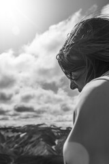 Fototapeta premium Side view of meditative young woman sitting on top of mountain
