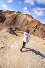 View from top of young woman walking downhill on sand dune