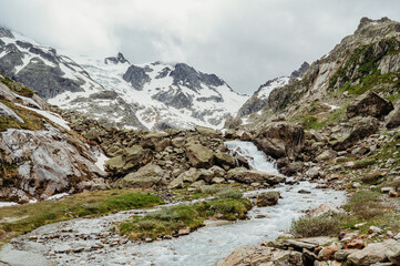Fototapeta na wymiar Waterfall with river at Sustenpass in the swiss mountains