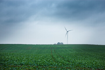 Wind turbine on a farmland in stormy wether