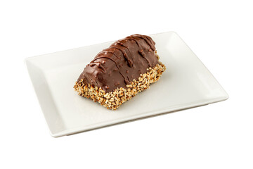 Dessert Cake from Malaga on white background. Cake with banana inside, covered with chocolate sauce and hazelnuts