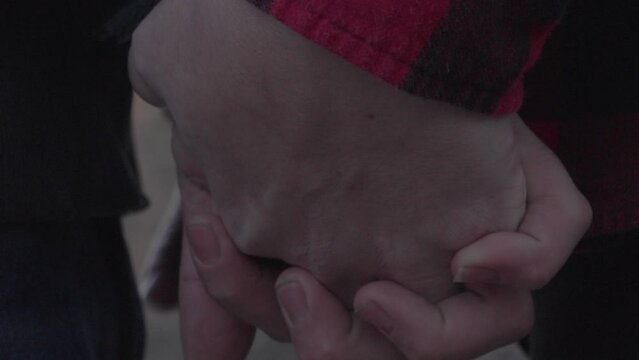 close up shot of a couple holding hands as the mans thumb caresses the woman's hand