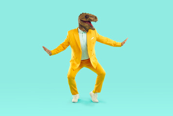 Fototapeta na wymiar Funny showman in yellow suit and rubber dinosaur mask dancing on turquoise background. He spreads his arms to the sides and squats slightly. Banner for advertisement, marketing with funky man.