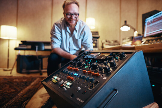 Music producer looking at audio equipment in his recording studio