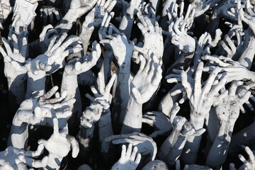 Hands of people pulled with entreaty. Wat Rong Khun (White Temple) in Chiang Rai city, Thailand....