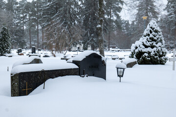 grave stones at cemetery covered in snow
