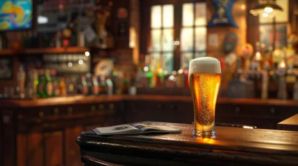 Foto op Canvas A glass of beer on the background of a bar. Yellow liquid with bubbles and foam in a glass. © Vladimir
