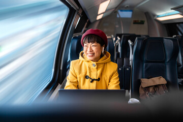 Beautiful asian woman commuting to work by high speed train. Enjoying first class ride.