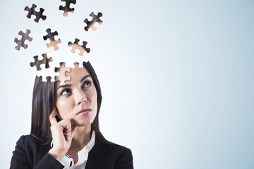Puzzle headed thoughtful businesswoman portrait on light background with mock up place. Solution, decision and brainstorm concept.