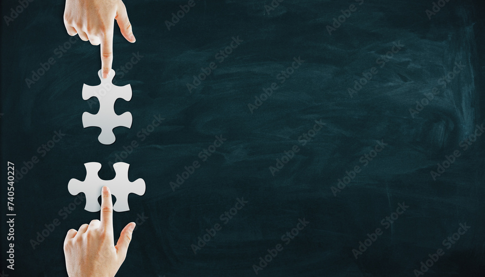 Wall mural male hands putting puzzle pieces together on chalkboard background with mock up place. teamwork and 