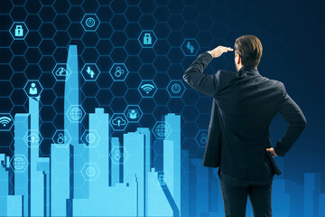 Back view of young businessman looking at creative digital city on blue hexagonal background....