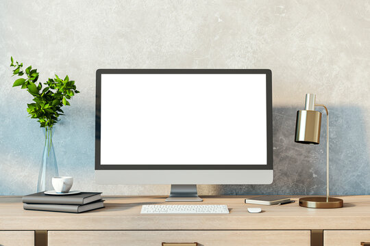 Contemporary designer desktop with empty white computer monitor, lamp, supplies and other items. Concrete wall background. Mock up, 3D Rendering.