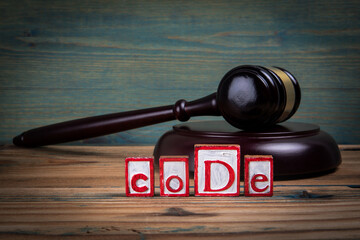 CODE. Red alphabet letters and judge's gavel on wooden background. Laws and justice concept