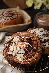Delicious rolls with toppings and almond on table, closeup. Sweet buns