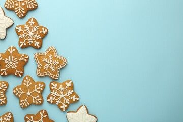 Tasty star shaped Christmas cookies with icing on light blue background, flat lay. Space for text
