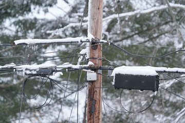 Utility pole and wires covered with snow in blizzard