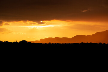 mountain silhouette and orange cloudy sky at sunset