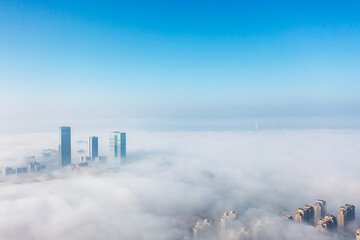 Fototapeta na wymiar Aerial view of the city in the fog. Skyscrapers above the fog
