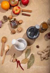 Fototapeta na wymiar Marble mortars for grinding spices among spices and products on a beige background
