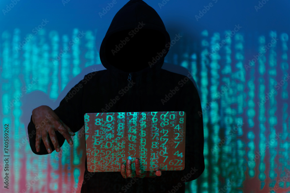 Poster a hacker is sitting in a dark room, hunched over a laptop computer. the hacker is wearing a hoodie a