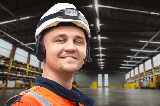 Large Storage Facility with Shelves and Boxes. A person in safety gear is working in the warehouse.