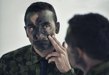 Soldier, man and face in mirror with camouflage paint with thinking, decision or brave to fight...
