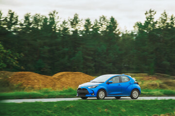 Speeding on a Nature Landscape with a Sporty Vehicle in the Evening Light