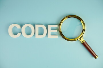 Code alphabet letters with magnifying glass on blue background