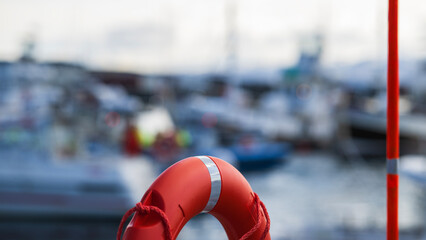 Maritime background- lifebuoy in front of a blurry harbor scene