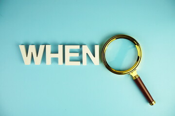 WHEN alphabet letters with magnifying glass on blue background