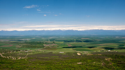 Fototapeta na wymiar Scenic panorama of Alazani Valley in Georgia. Green fields and hills landscape