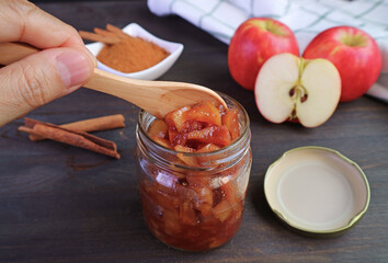 Hand scooping delectable homemade caramelized apple cinnamon compote