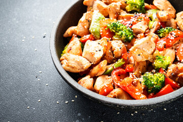 Stir fry chicken and vegetables and sesame in the wok. Asian cuisine. Close up.