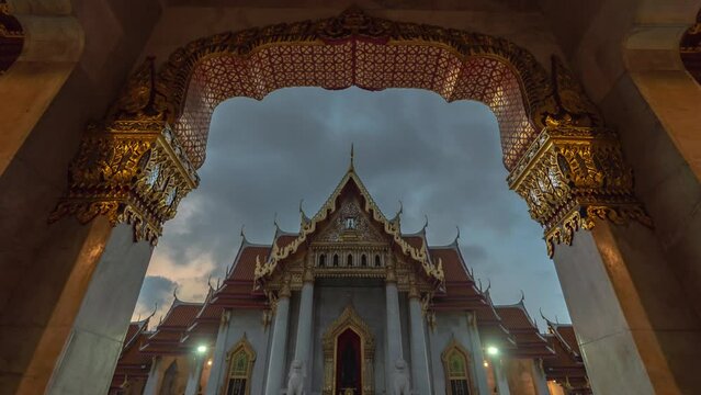 Time lapse Looking through the Beautiful gate of Wat Benchamabophit..The architecture is intricate and beautiful..Early in the morning, clouds float above Wat Benchamabophit. landmark in Bangkok