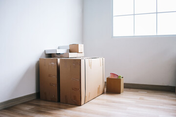 Moving in. Stack of cardboard boxes in the empty room with copy space.