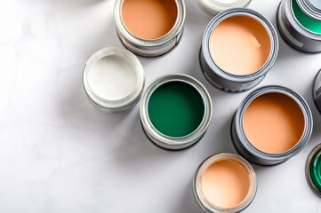 Tiny sample paint cans during house renovation, process of choosing paint for the walls, Peach Fuzz...