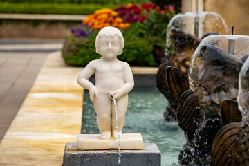 Statue of a naked pissing boy in the form of a street fountain in a square in Da Nang, Vietnam, closeup - obrazy, fototapety, plakaty