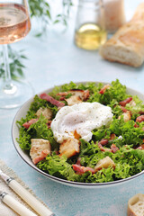 A bowl with salad lyonnaise served for lunch