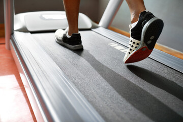 Fitness, feet and person running on treadmill in gym for health, wellness and body training....