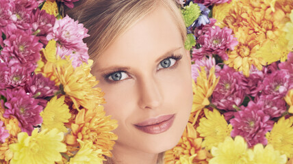 Naklejka premium Woman, portrait and flowers with makeup for beauty, creativity and wellness with spring aesthetic and floral art. Model, organic cosmetics and carnation plants for facial glow, smile and flowerbed