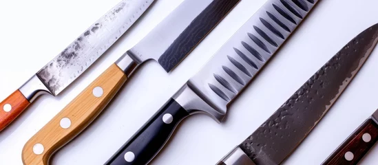 Fotobehang Collection of assorted kitchen knives arranged neatly on a clean white background © AkuAku