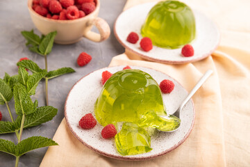 Mint and raspberry green jelly on gray concrete and orange linen textile. side view, selective focus.