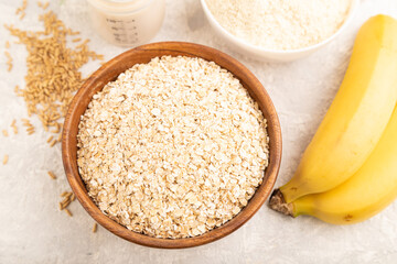 Powdered milk and oatmeal, banana baby food mix, on gray concrete, top view