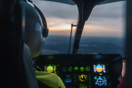Pilot of helicopter emergency medical service flying over landscape at dusk. Themes emergency medicine, rescue, and emergency help..